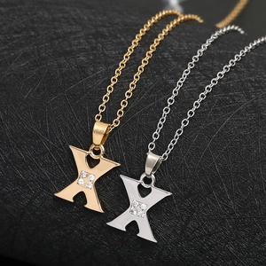 Macro shot of X-shaped necklaces in gold and silver finish with CZ stone center