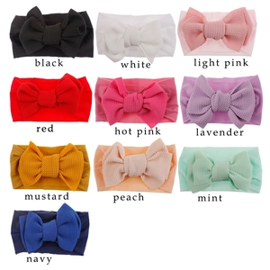 Detail showing 10 colors of waffle texture nylon baby headbands with soft elastic bows