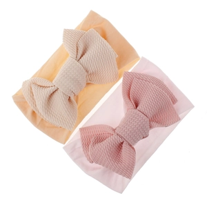 Detail of soft waffle texture nylon baby headbands in pale pink and light orange