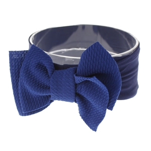 Detailed close-up of dark blue knotted nylon baby headband with soft ribbed texture