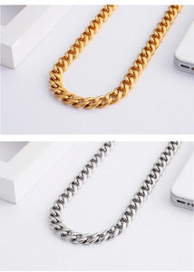 Close-up of polished stainless steel Cuban link necklaces in gold and silver finishes
