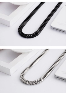 Close-up of bold Cuban chain necklaces in black and silver stainless steel finish