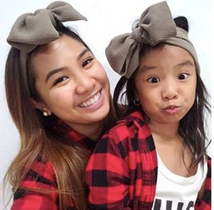 Mother and daughter wearing matching textured olive green bow headbands for hair styling