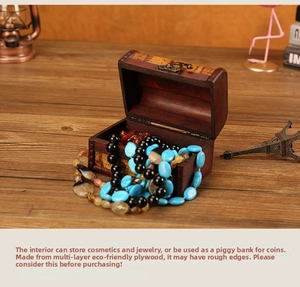 Antique wood storage box with metal clasp showing beads inside on a rustic desk