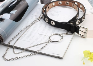 Detail of black punk leather belt with silver eyelets, decorative metal chain and ring
