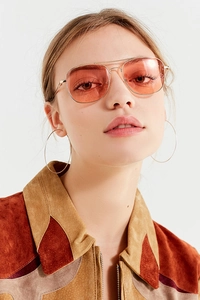 Detail of vintage pilot sunglasses with double bridge and orange tinted lenses on a model