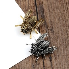 Macro detail of vintage bee brooches with antique gold and silver plating and crystals