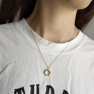 Detail of twisted gold ring pendant on a fine 925 sterling silver chain necklace