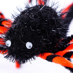 Halloween black fuzzy spider decoration with orange striped legs and googly eyes