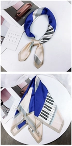 Detail of silk-like scarf featuring piano key pattern and elegant blue-beige color blocks