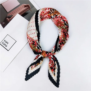 Vue détaillée d'un foulard plissé carré avec des motifs à pois rouges et roses