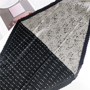 Détail d'un foulard plissé avec pois noirs et motifs abstraits gris sur le tissu