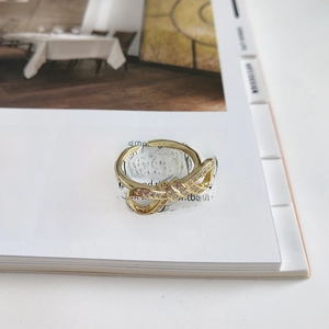 Detail of gold bow ring with pink zircon pave setting on a fashion magazine background