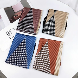 Gros plan de quatre foulards en soie plissés aux motifs géométriques de pied-de-poule colorés