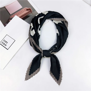 Vue détaillée d'un foulard en soie plissé aux tons noir et gris sur fond blanc