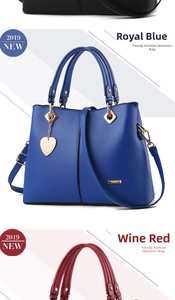 Detailed view of royal blue PU leather handbag with a heart-shaped metal charm and strap