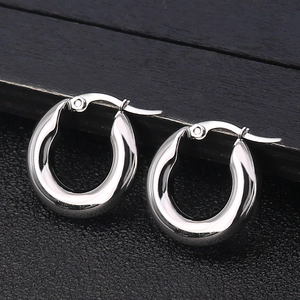 Polished silver stainless steel thick hoop earrings on a dark textured background