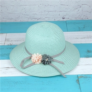 Mint green woven straw sun hat with grey polka dot ribbon and floral accents for beach vacations