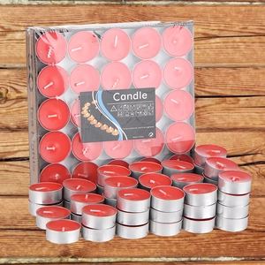 50-pack red paraffin tea light candles in aluminum holders on a wooden background