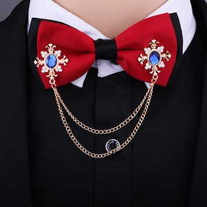 Close-up of red and black bow tie with golden cross brooches and hanging metal chains