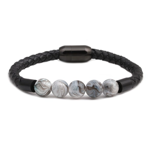 Close-up of black braided leather bracelet with marble pattern beads and magnetic clasp