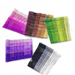 Flat lay of colorful glittery metal wave bobby pins in purple, pink, and green