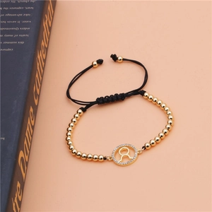Macro shot of gold beaded bracelet with Taurus zodiac charm and sparkling zircon stones