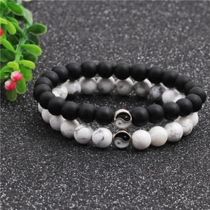 Close-up of Yin Yang couples beaded bracelets with white turquoise and black matte beads