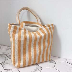 Detailed close-up of thick canvas material with yellow vertical stripes on a tote bag