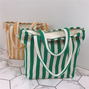 Detail of green and yellow striped canvas tote bags with zipper closure and thick fabric