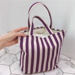 Detailed view of striped canvas tote bag with purple and white vertical patterns