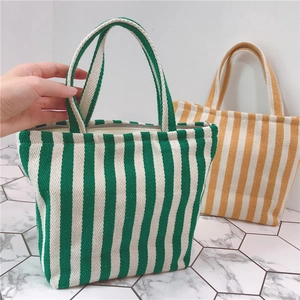 Close-up of green and yellow striped canvas handbags with thick durable handles