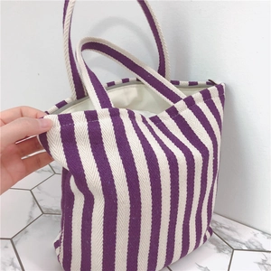 Detailed macro view of purple striped canvas tote with zipper closure and woven texture