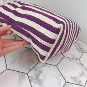 Detail view of the durable canvas texture and spacious base of the striped tote bag