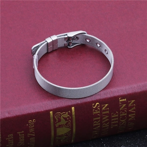Detailed view of silver mesh stainless steel watch strap on a red vintage book background