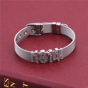 Detail of silver mesh bracelet with crystal 1314 charm and buckle on a red texture