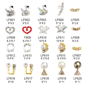 Macro detail of 20 assorted 3D nail art charms including crystal swans and pearl butterflies