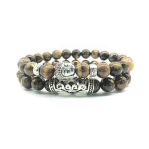 Close-up of tiger eye bead bracelets with silver Buddha head and ornate metal spacers