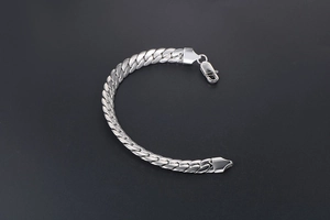 Detail shot of silver stainless steel Cuban link bracelet with secure lobster clasp