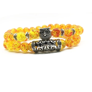 Detail of owl charm and amber-colored beads on a double-layer vintage bracelet