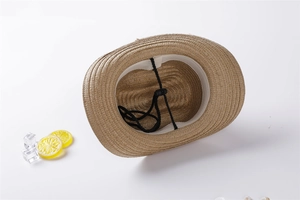 Detail view of brown straw sun hat interior with sweatband and adjustable black wind rope