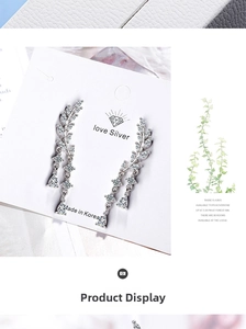 Detailed view of silver wing earrings with sparkling rhinestones and long tassels