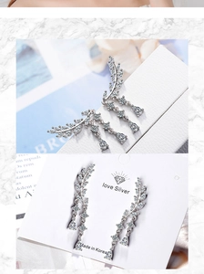 Detail of silver long drop earrings with marquise-cut stones and leaf-shaped tassels