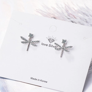 Elegant silver dragonfly stud earrings with white zircon crystals on a jewelry card