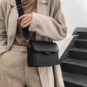 Classic black crossbody square bag with wide nylon strap styled on female model