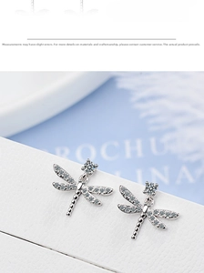 Macro detail of silver dragonfly stud earrings with sparkling pave-set white crystals