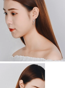 Detail of silver moon and star tassel earrings worn by model with sparkling stones