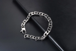 Macro shot of silver mesh geometric chain bracelet links on black leather background