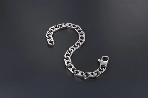 Detailed shot of silver mesh link bracelet with lobster clasp on dark background