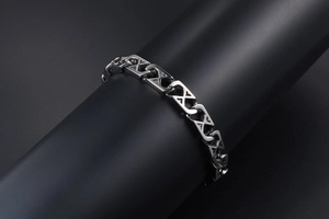Close-up of silver titanium steel mesh bracelet with X-shaped geometric links on black stand